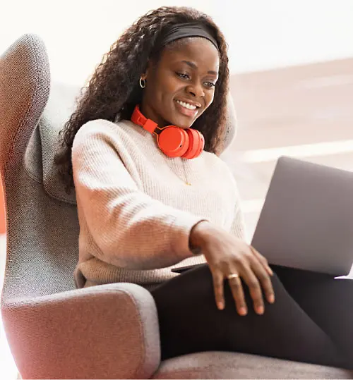 Orryana, a Henkel employee, working on her laptop in a comfy chair