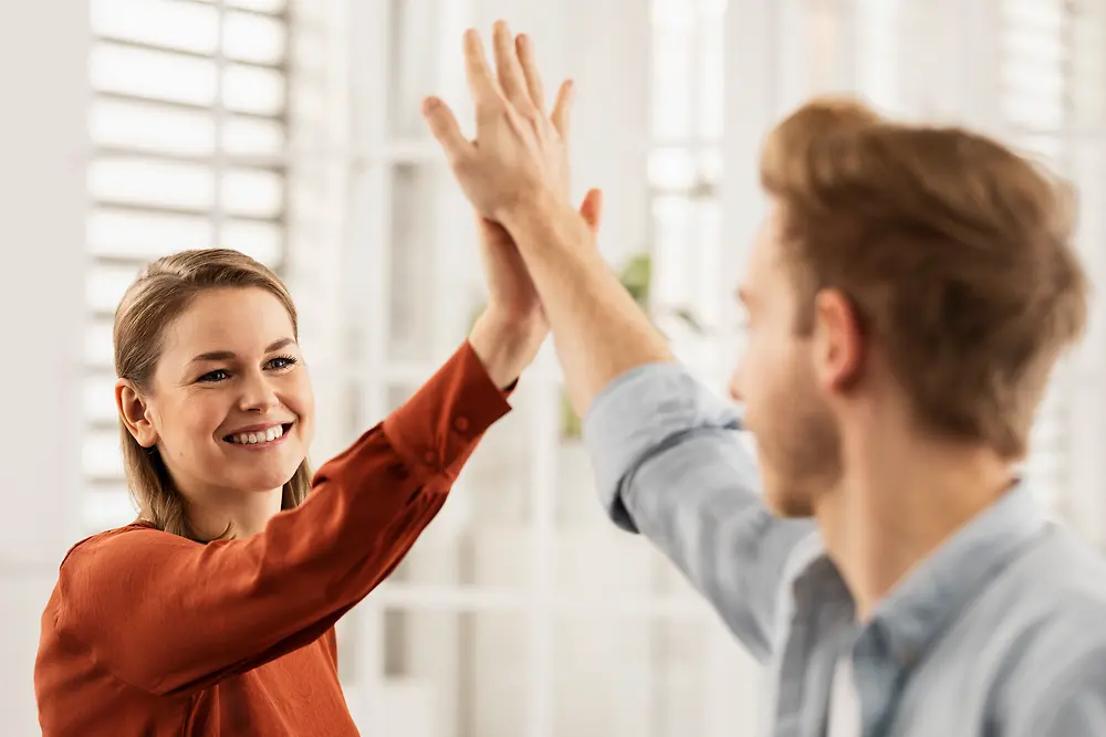 Friendly colleagues give each other a high five. 