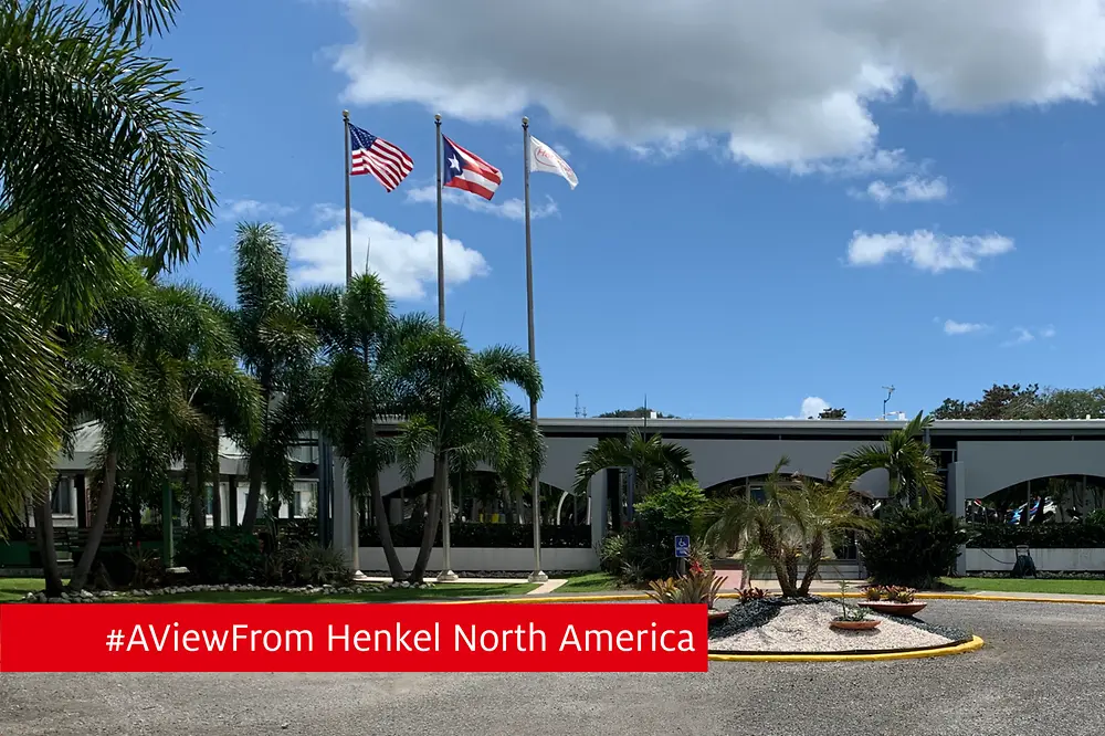 Front exterior view of a manufacturing facility surrounded by lush foliage.