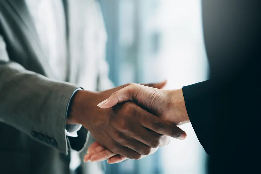 Black and white colored person shaking hands 