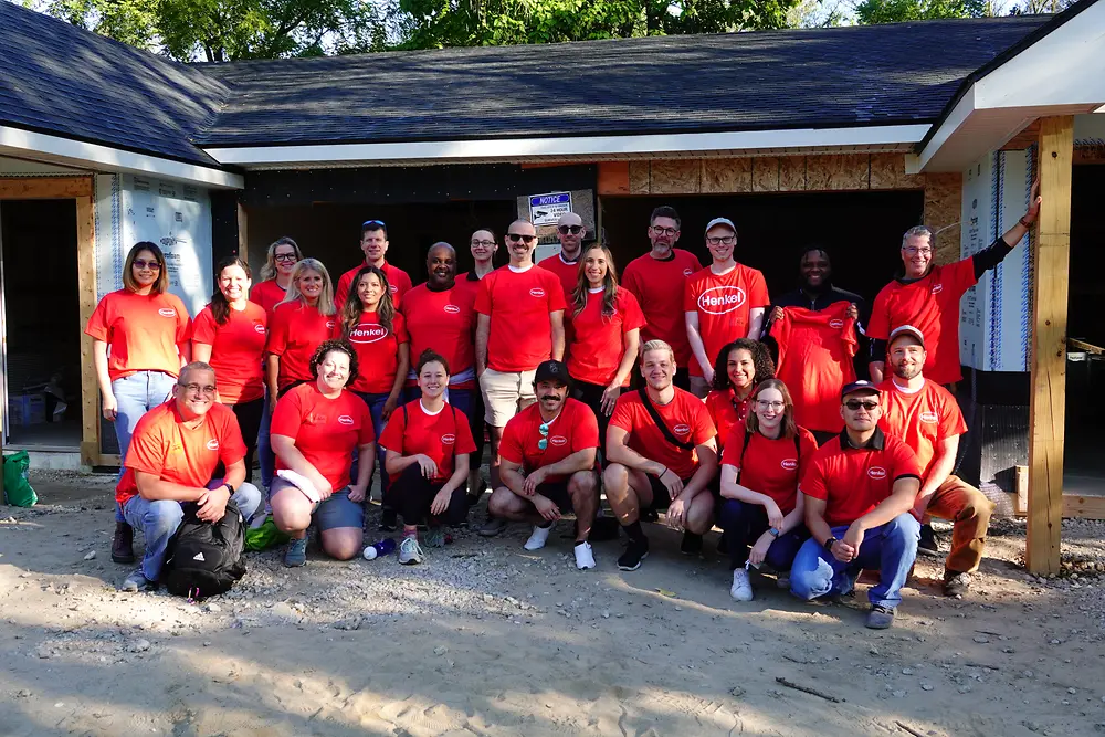 A group of people in red shirts smiling at camera