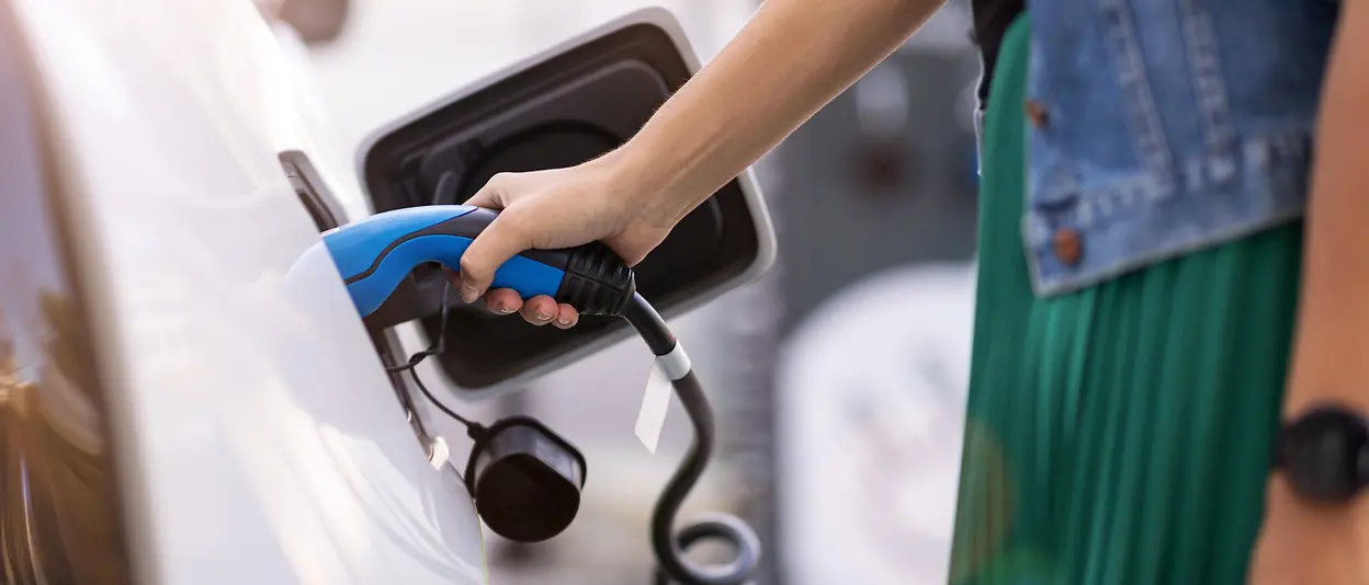 A driver charges her electric vehicle.