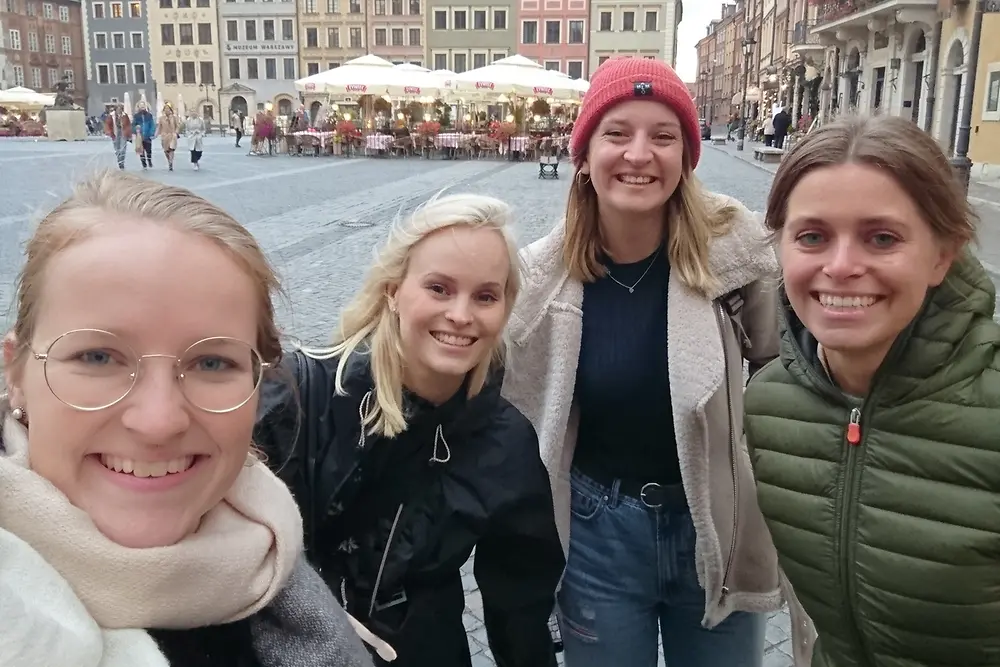 Four women are standing in a marketplace in Warsaw, Poland.