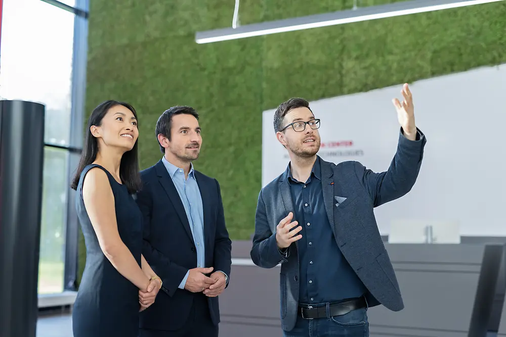 A customer experience tour guide shows a group of two customers the Inspiration Center Düsseldorf.