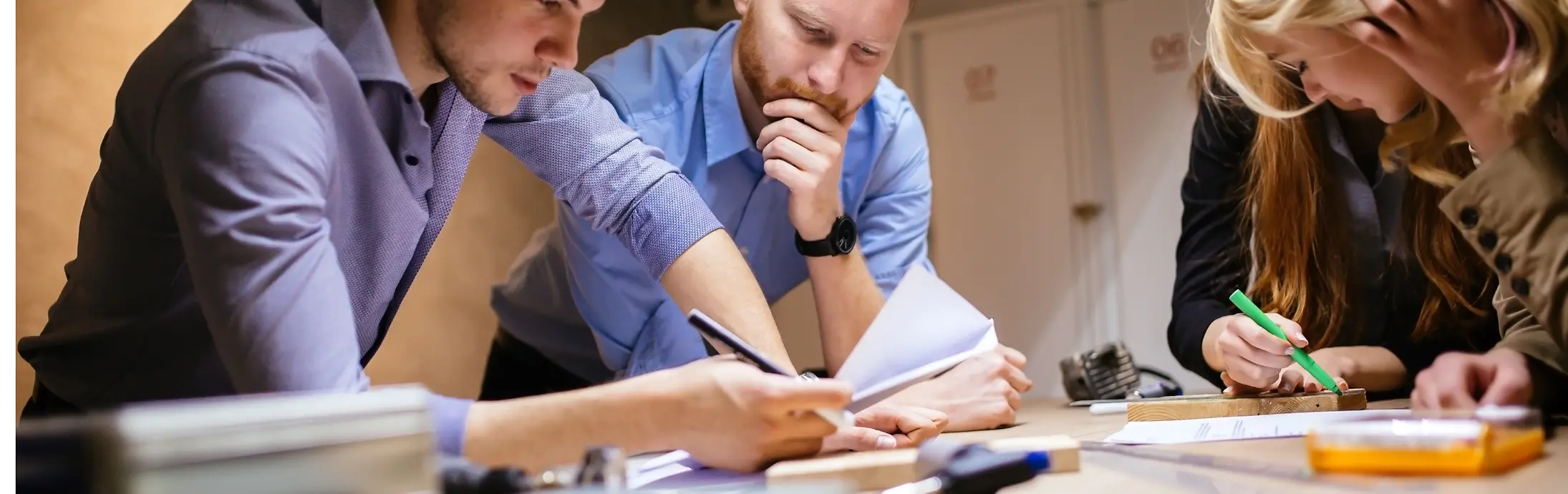 A group of 4 colleagues leaning on a table and checking some papers