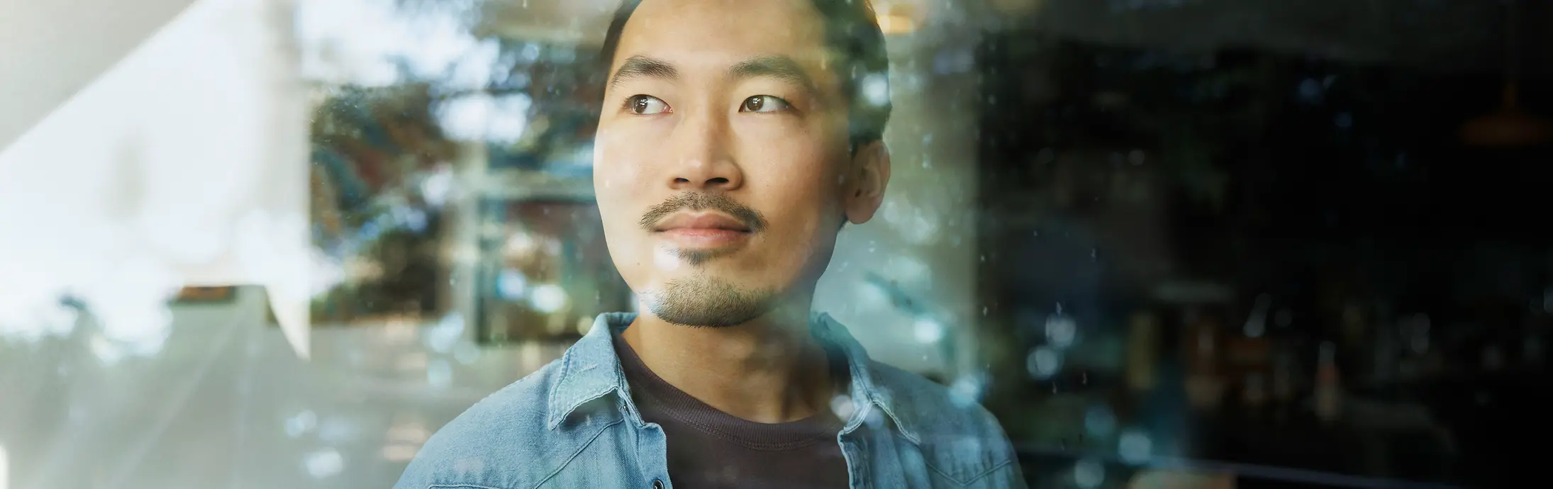 A man looks through a glass window.