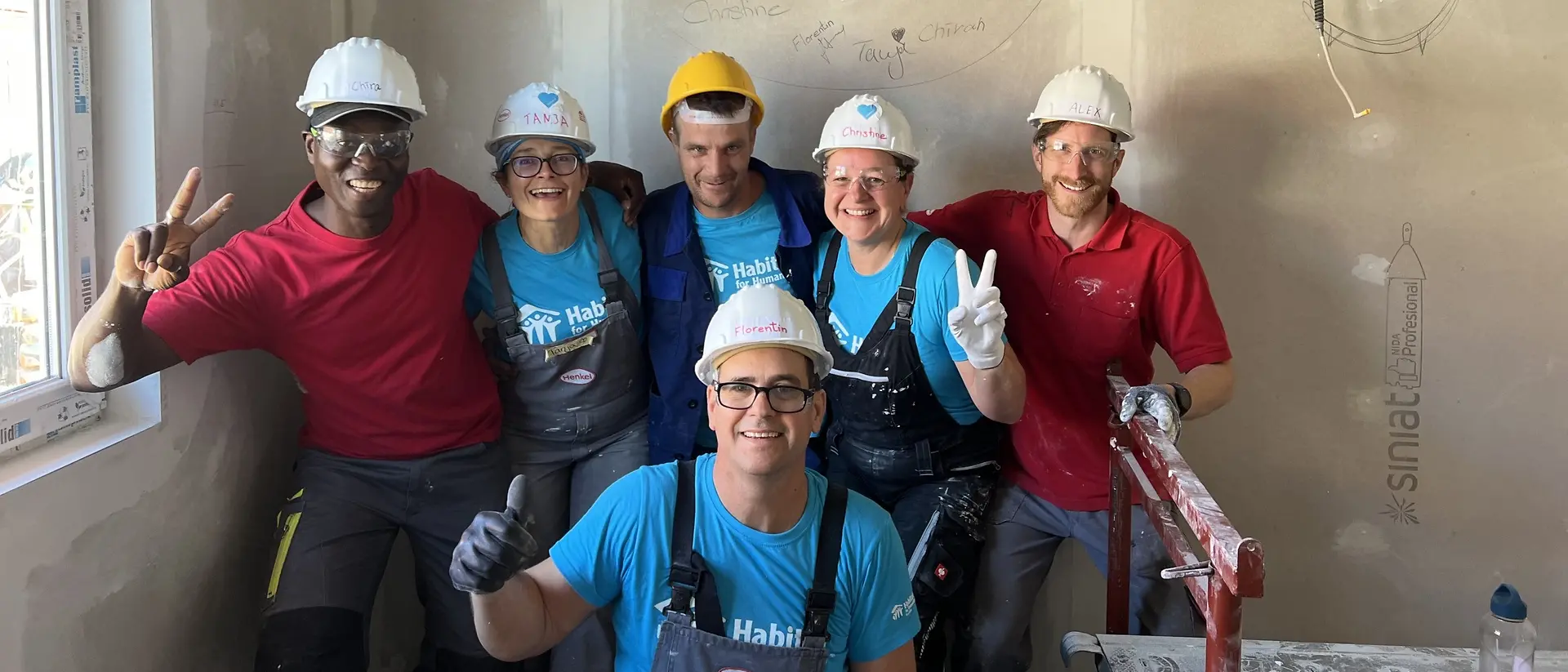 A group of volunteers in protective clothing poses for a group photo.