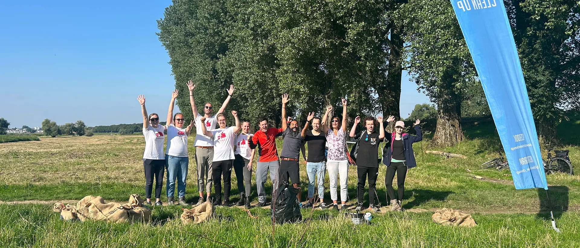 A group of volunteers cheers as they join the event to collect thrash.