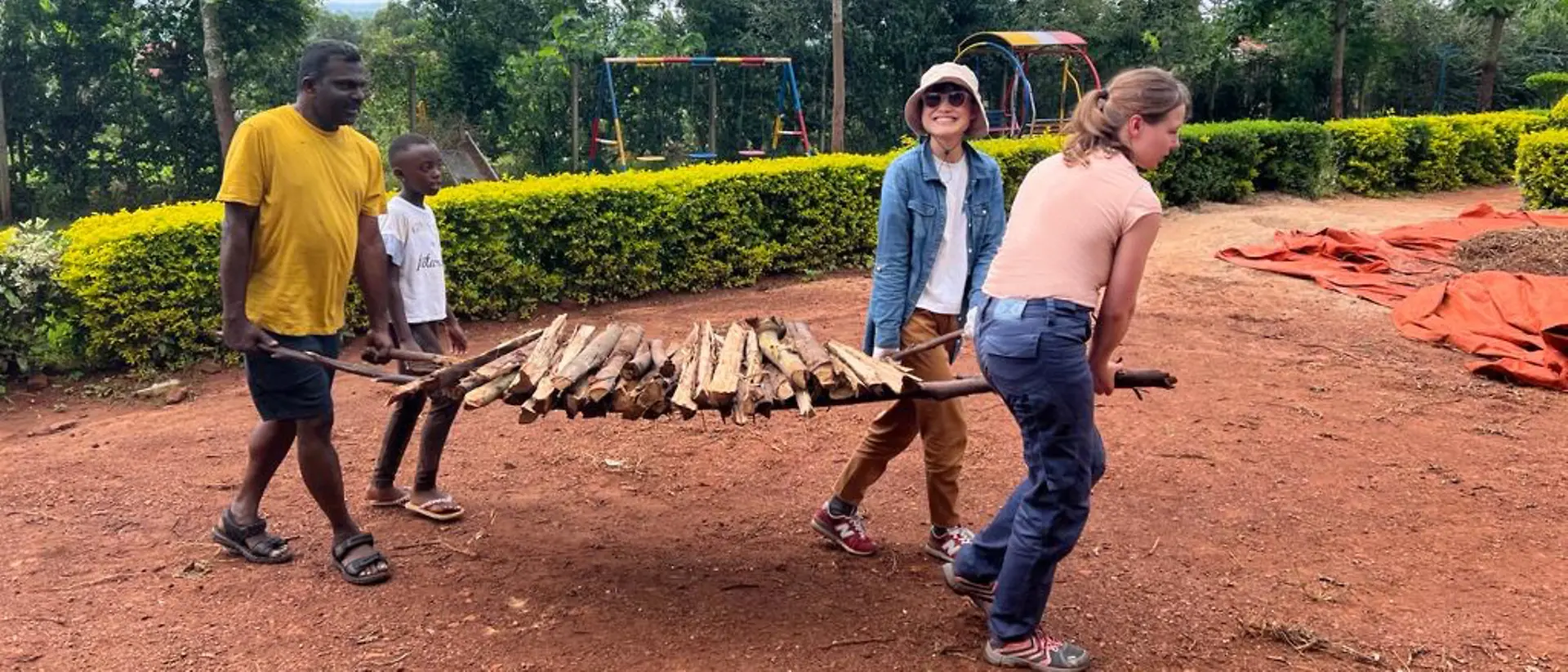 Volunteers help to carry wood.