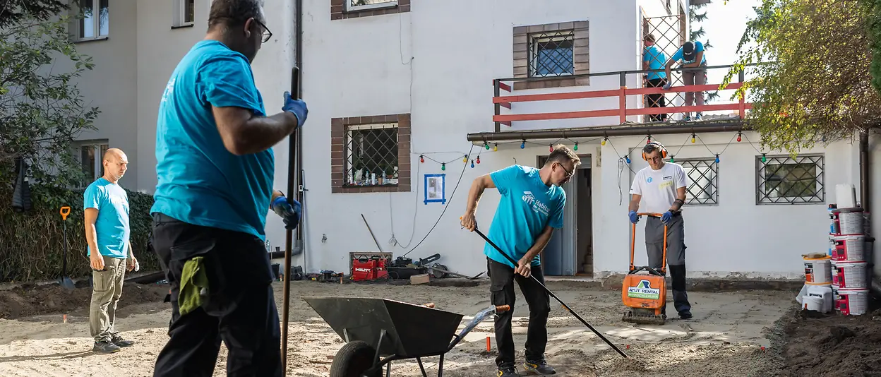 The volunteers prepare the home’s garden to install outside flooring.