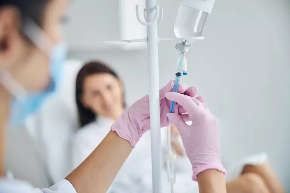 Hands of a nurse holding a syringe 