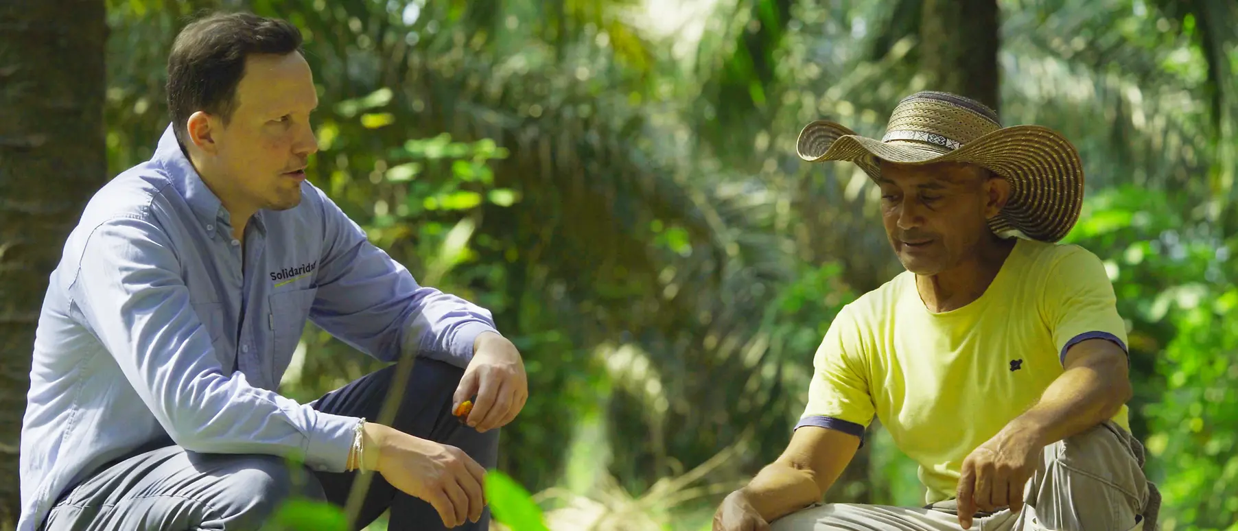 Two men face each other in a dense jungle environment