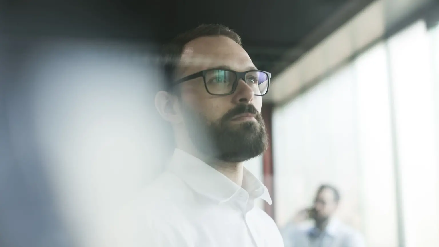 A bearded man wearing glasses.