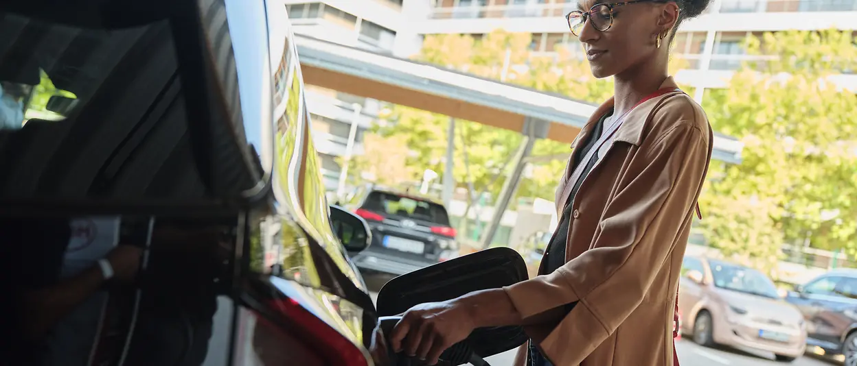 A woman is charging her electric car.