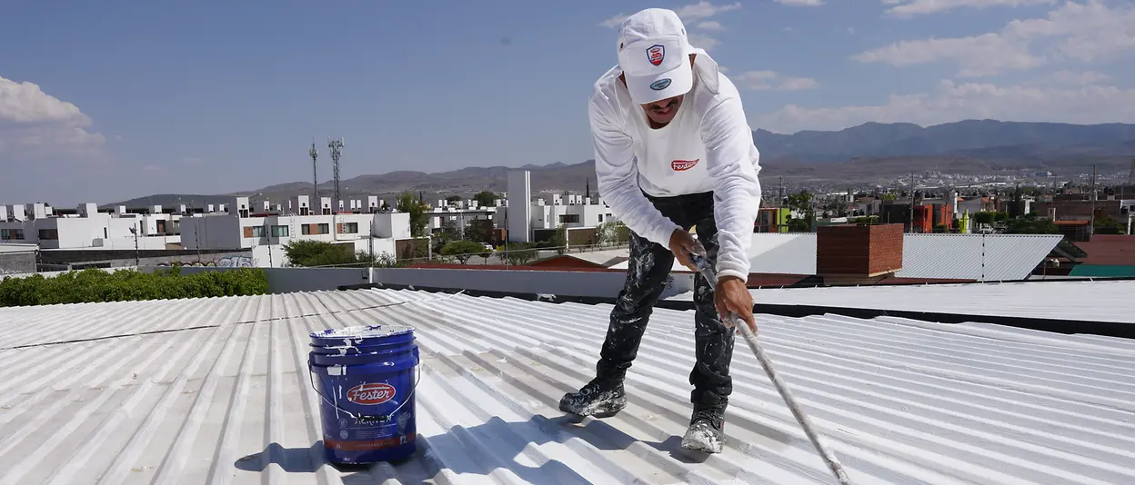 Man applying Fester Acriton Green Shield to a roof