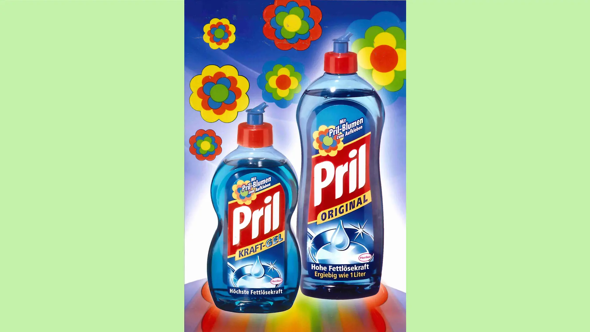 Advertising motif with a Pril-Kraft-Gel and Pril-Original bottle on a background running from medium blue at the top edge down to white. Colorful Pril flowers are placed above the bottles.